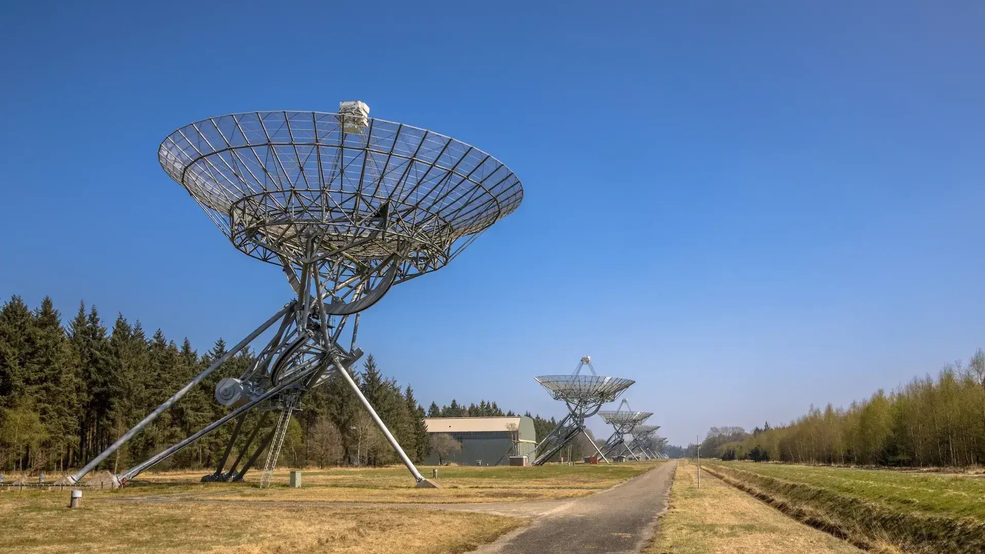 Row of radio telescopes in daytime